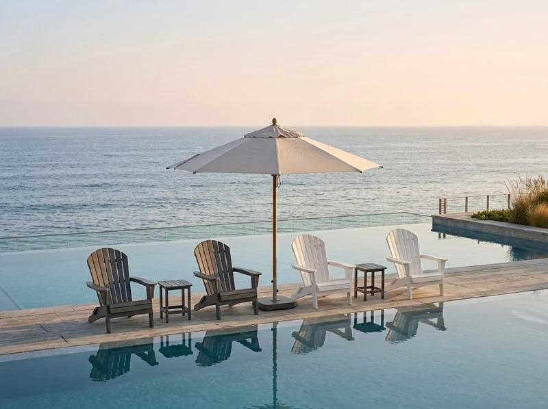 Weather-resistant HDPE folding Adirondack chairs arranged along a luxury resort oceanfront infinity pool deck