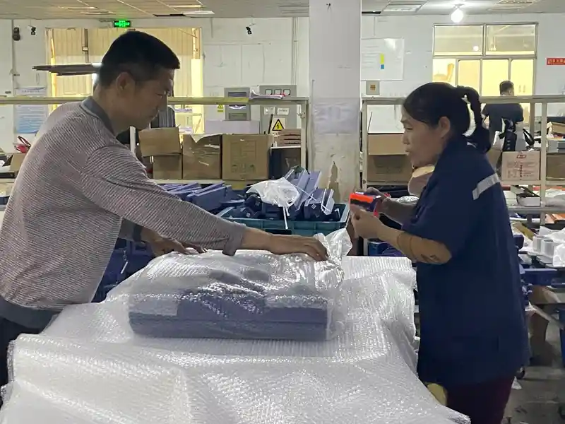 Workers performing protective packaging and bubble wrapping on HDPE Adirondack chairs for international export